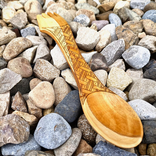 kolrosed spork A basket weave kolrosed design on an apple wood spork, resting gently on the pebbles at the rear of a beach