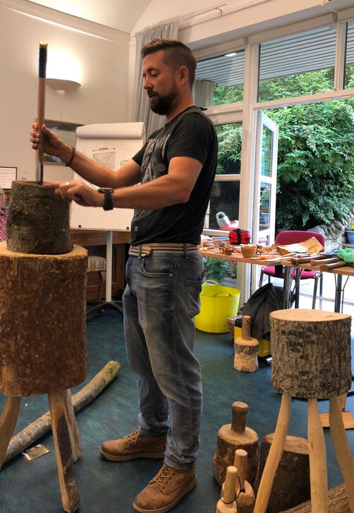 nick demonstrates splitting a round log techniques using an axe and mallet