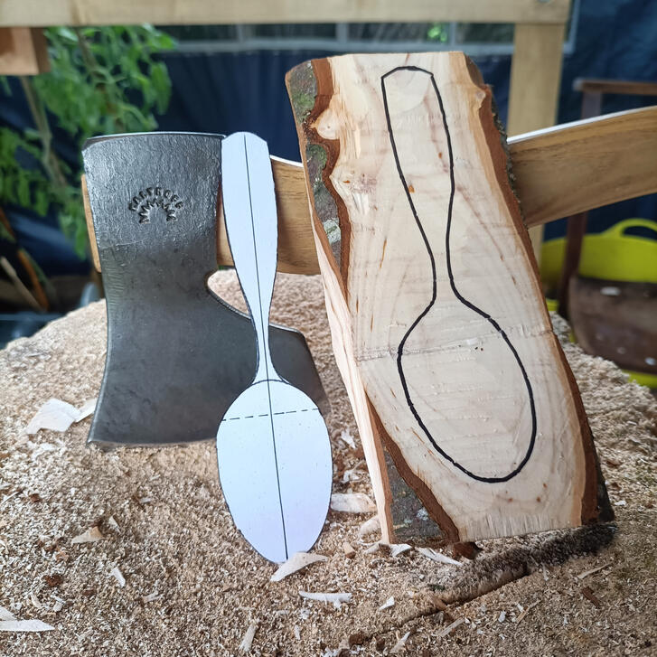 life on the block a spoon template and roughed blank rest atop a carving block and a kalthoff carving axe