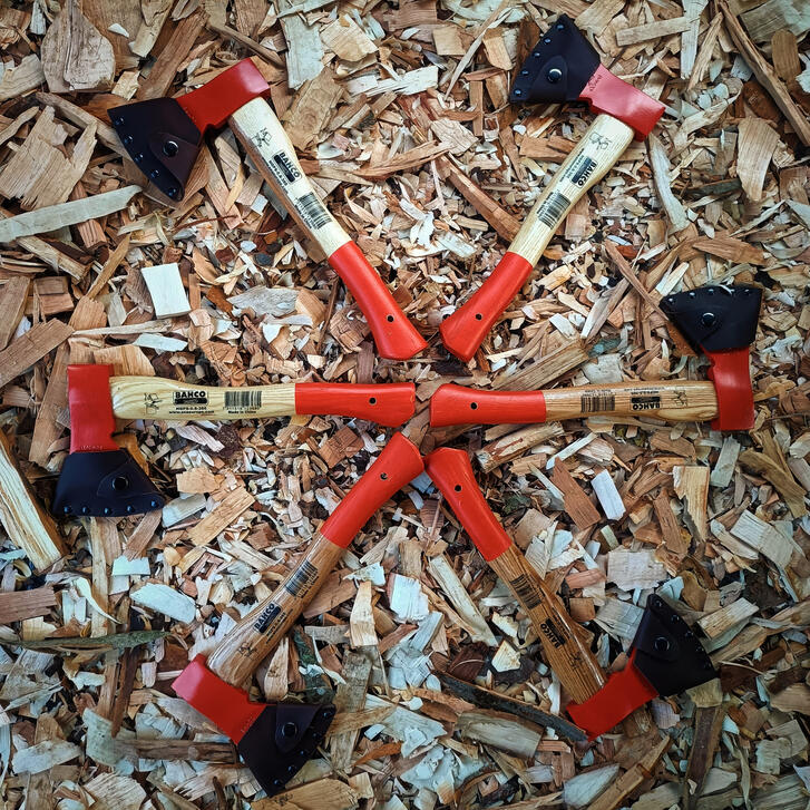 a circle of axes 6 reground bahco carving axes lying on a bed of wooden shavings on the workshop floor